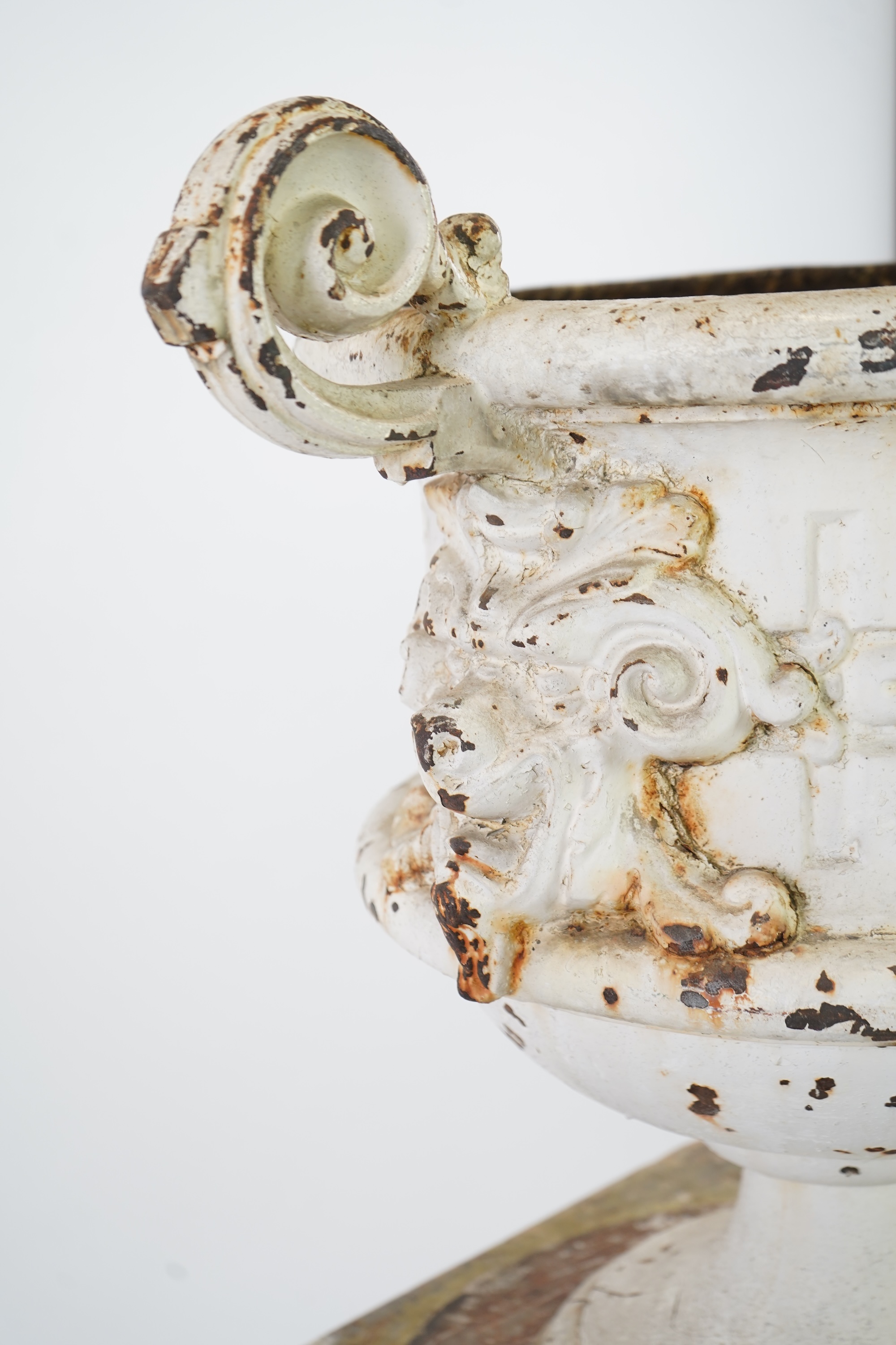 A Victorian white painted cast iron urn and a painted faux marble pedestal